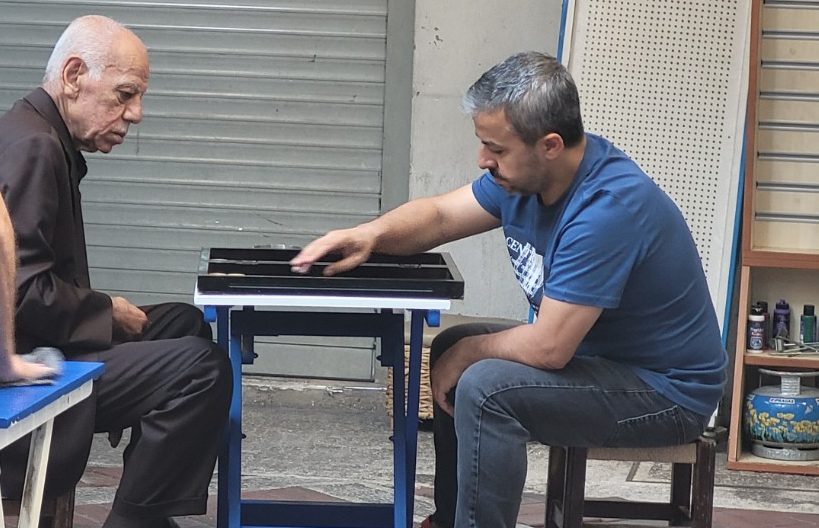 Men talking and playing backgammon at a small Istanbul café