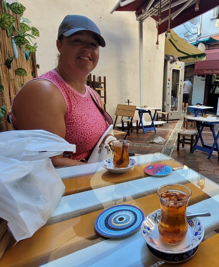 Jenn sitting at a café table with Turkish tea in Istanbul
